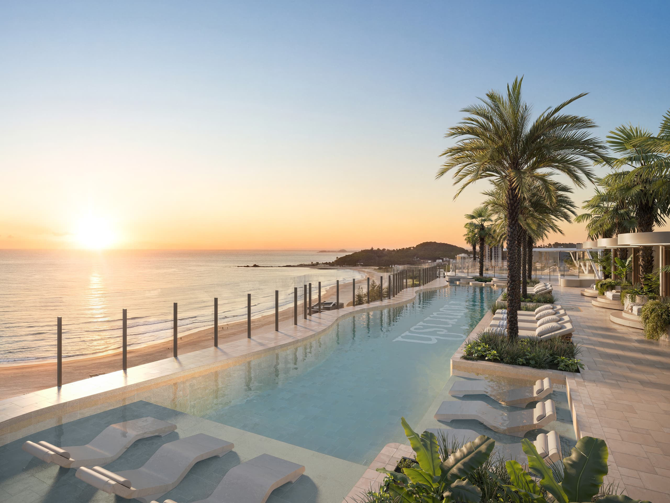 The northern community rooftop at golden hour, pool stretching toward the headland